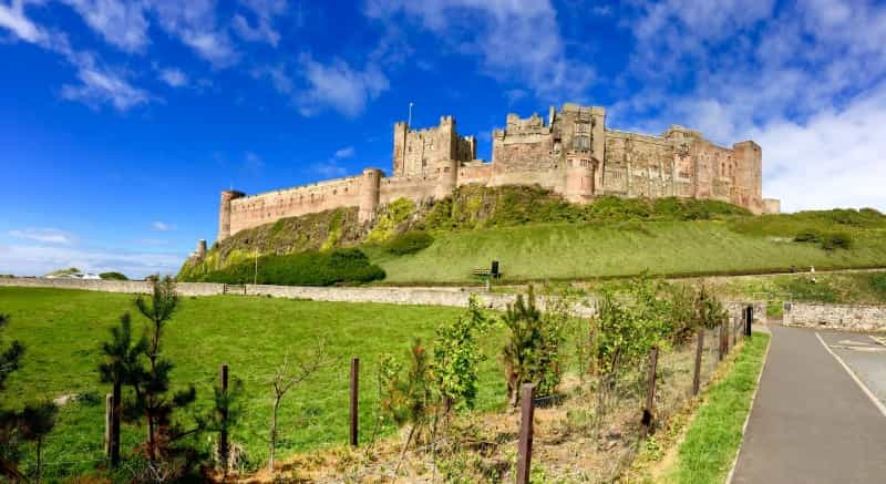 Bamburgh Castle standing guard above the spectacular coastline (Sheila Hammond on Unsplash)