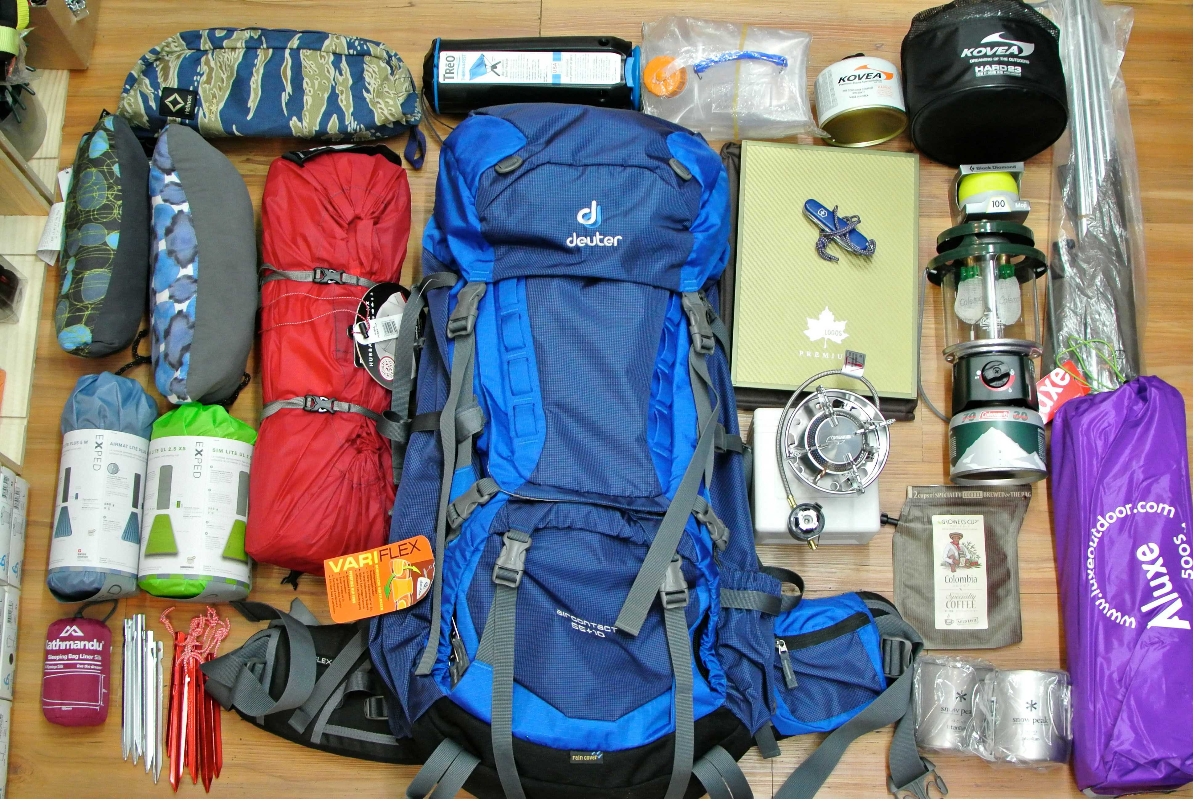Image shows camping equipment laid out on a floor ready to pack into a rucksack