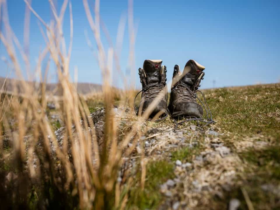 A pair of walking boots in a stony field