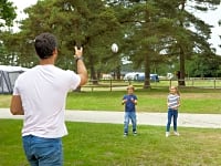 Family playing catch on the touring pitch Family playing catch on the touring pitch
