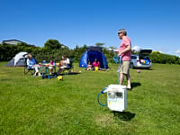 Family at the electric grass tent pitch at Southerness Holiday Park Family at the electric grass tent pitch at Southerness Holiday Park