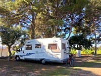 Op grind en aarde staplaats voor camper , met elektriciteit