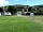 Parc Farm Caravan Park: The entrance to the touring area with shower block and waste area hidden just behind the hedge