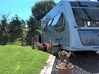 Tomt för husvagn med vatten, el och avlopp på gräs och grus