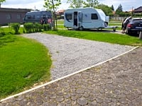Tomt för husvagn med vatten, el och avlopp på gräs och grus