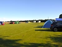 Op gras staplaats voor een tent zonder elektriciteit