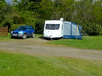 Parcel·la de terra dur amb electricitat per a caravanes (2 adults i 2 nens)